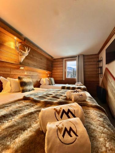 a hotel room with two beds and a window at Hôtel Ski Lodge - Chambres & Appartements - Village Montana in Val-d'Isère