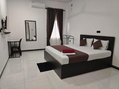 a bedroom with a bed and a mirror at SSS HOTEL in Trincomalee