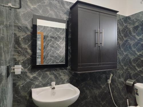 a bathroom with a sink and a mirror at SSS HOTEL in Trincomalee