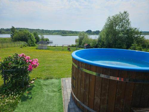 a large wooden barrel with a blue tub in a yard at Agroturystyka Golubie in Ełk