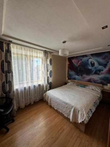 a bedroom with a bed with a painting of a movie at Кандавас 9 in Daugavpils
