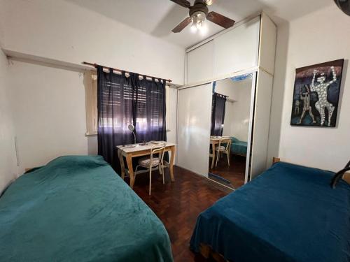 a bedroom with two beds and a table and a mirror at Casa Olivos in Olivos