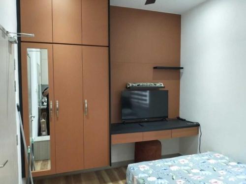 a bedroom with a tv and a cabinet and a bed at Sufi Idaman Studio for Islamic only in Nilai