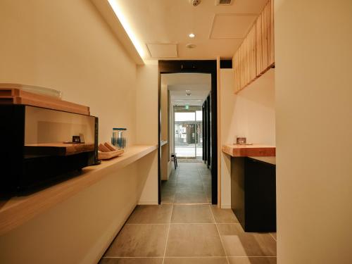 a hallway leading to a kitchen with a long counter top at THE SENSE HOTEL TOKYO in Tokyo