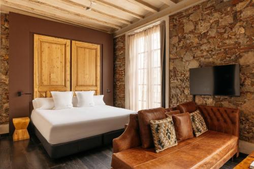 a hotel room with a bed and a couch at Aparthotel Arai 4* Superior in Barcelona