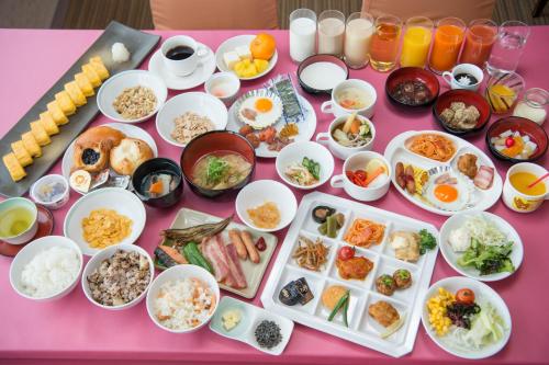 un tavolo rosa con molti piatti di cibo sopra di Shizunai Eclipse Hotel a Shinhidaka