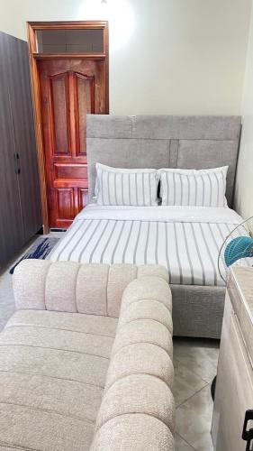 a bedroom with a large bed and a couch at Muyenga Studio Apartments in Kampala