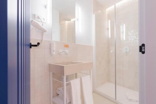 a white bathroom with a sink and a shower at SLEEP'N Valencia in Valencia