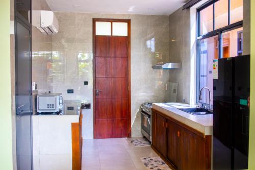 a kitchen with a wooden door and a sink at Matemwe Bluu Villa in Matemwe