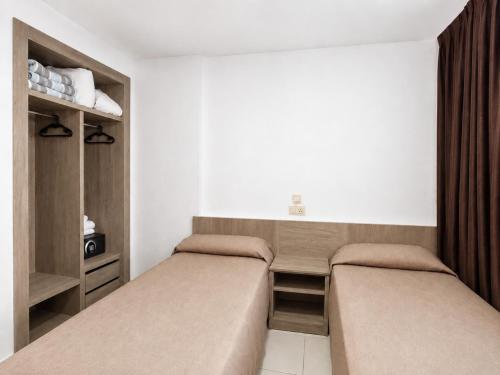 two beds in a small room withermottermottermottermottermott at Luxmar Apartaments By MC in Benidorm