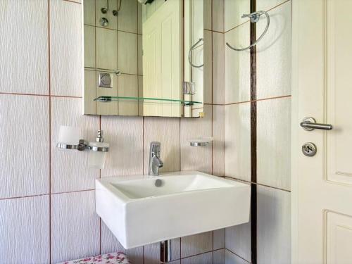 a bathroom with a white sink and a mirror at Kumbor sunny port with shared pool in Kumbor