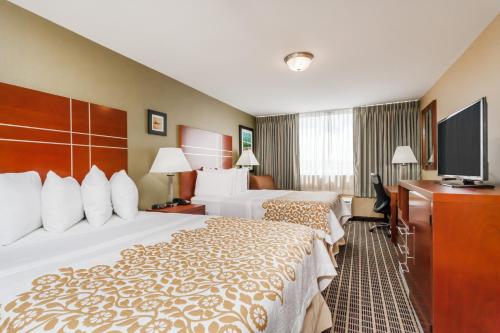 um quarto de hotel com duas camas e uma televisão de ecrã plano em Days Inn by Wyndham Windsor Locks / Bradley Intl Airport em Windsor Locks