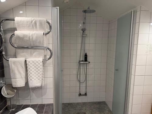 ein Badezimmer mit Dusche und weißen Handtüchern in der Unterkunft Hotel Wictoria in Mariestad