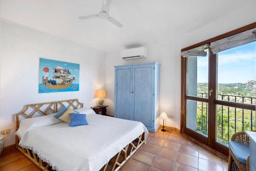 a bedroom with a bed and a large window at Villa Sardinia Costa Smeralda in Arzachena