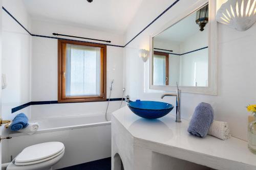 a bathroom with a blue bowl sink on a counter at Villa Sardinia Costa Smeralda in Arzachena