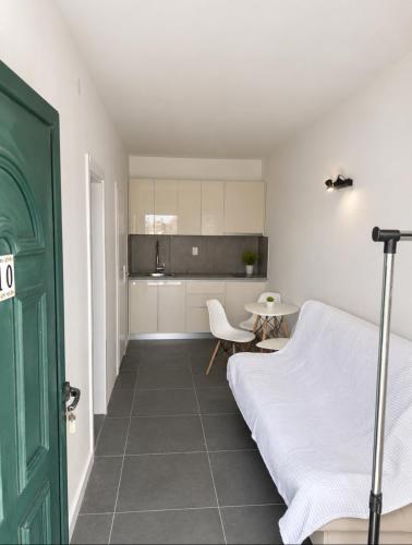 a bedroom with a bed and a table and a kitchen at Studios Annie in Bijela