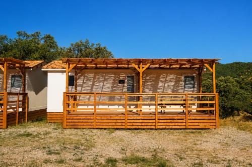 a wooden house with a wooden roof at Kampaoh El Pedroso in El Pedroso