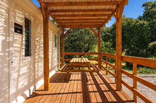 a wooden porch with a pergola on a house at Kampaoh El Pedroso in El Pedroso