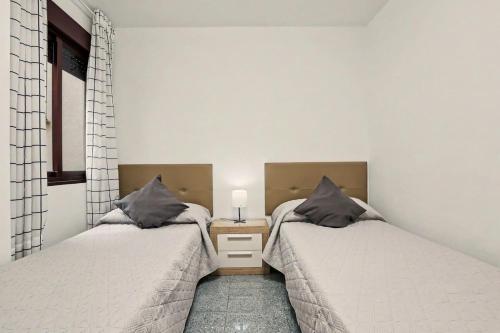 a bedroom with two beds and a table with a lamp at NG CANDELARIA - Tenerife in Candelaria