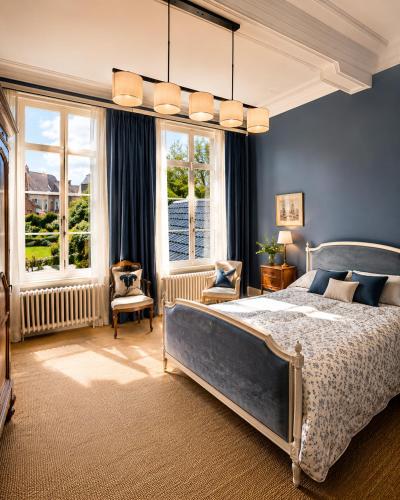 a bedroom with a bed and a blue wall at Villa Theresa à 25 min de PAIRI DAIZA in Soignies