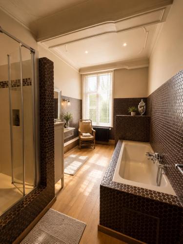 a large bathroom with a tub and a shower at Villa Theresa à 25 min de PAIRI DAIZA in Soignies
