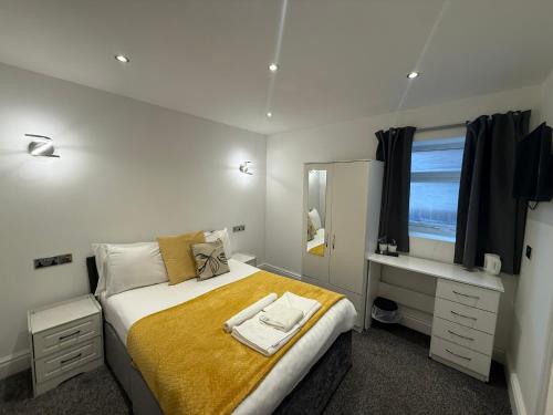 a bedroom with a bed and a desk and a mirror at The President Hotel in Blackpool