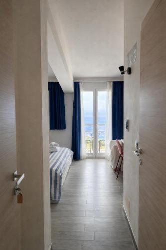 a bedroom with a bed and a door with a window at Blue Sky House in Taormina