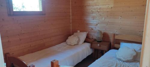 a room with two beds in a log cabin at Chalet rocenel in Le Malzieu-Ville