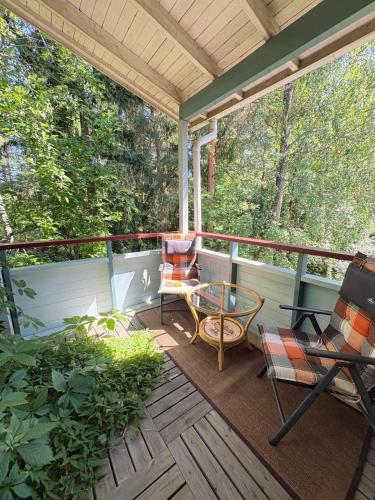 a screened in porch with chairs and a table at Helsinki Hallainvuori yksityismajoitus in Helsinki