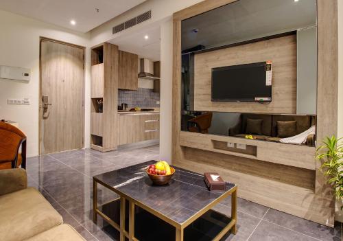a living room with a tv and a table at Rhythm Gurugram, Hotel & Suites, Sohna Road, Sector 68 in Gurgaon
