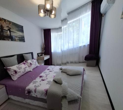 a bedroom with a purple bed and a window at Cazare Herculane in Băile Herculane