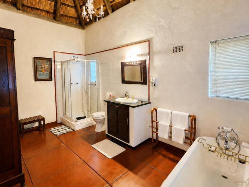 a bathroom with a tub and a sink and a toilet at Quiet Mountain Country House in Hekpoort