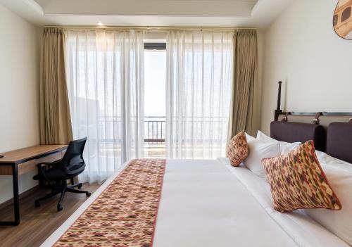 a hotel room with a bed and a desk and a window at Rhythm Gurugram, Hotel & Suites, Sohna Road, Sector 68 in Gurgaon
