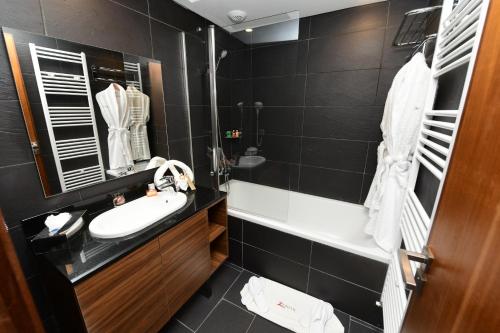 a bathroom with a sink and a tub and a mirror at ZEPHYR Ifrane in Ifrane