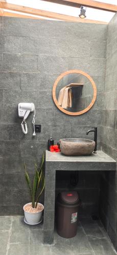 a bathroom with a sink and a mirror at D'Cabin Villa Uluwatu in Uluwatu