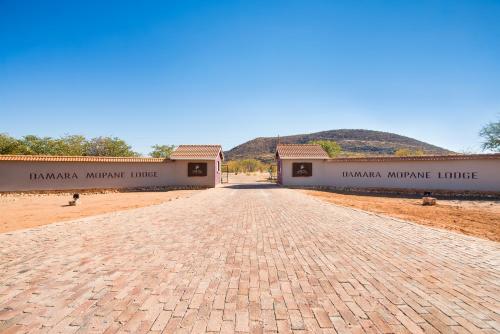 a road leading to the entrance of a building at Gondwana Damara Mopane Lodge in Mopane Pos