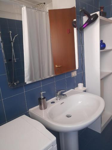 a bathroom with a sink and a toilet and a mirror at Diana Apartment Savona in Savona