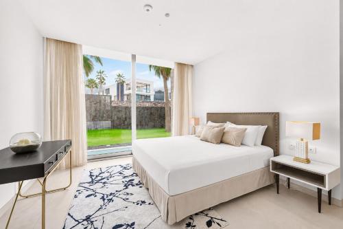 a bedroom with a white bed and a large window at CHALET 95, Lujo y Piscina Infinity in Adeje