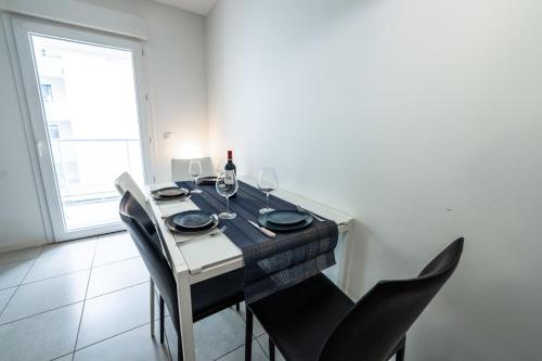 a dining room table with chairs and a bottle of wine at Spacious apartment in Talence in Talence
