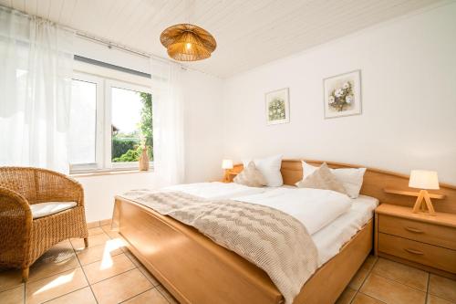 a bedroom with a bed and a chair and a window at Blumenhaus mit Terrasse in Waren