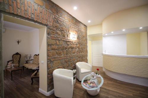 a living room with a stone wall and white chairs at Freedom Love B&B in Rome