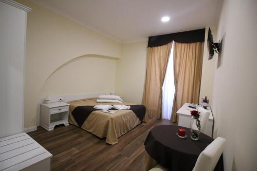 a bedroom with a bed and a table and a window at Freedom Love B&B in Rome