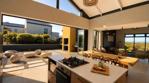 an open kitchen and living room with a table and a stove at 401 Kingfisher in Gansbaai
