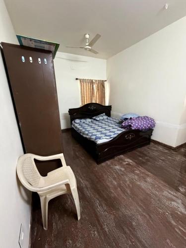 a bedroom with a bed and a chair in it at Senthur Bavanam in Udumalaippettai