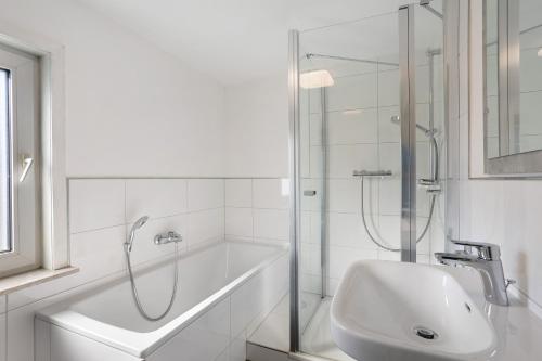 a white bathroom with a shower and a sink at Fewo Diemelrauschen in Eimelrod