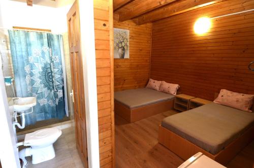 a small room with two beds and a toilet at Vila Flora Costinesti in Costinesti