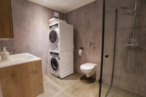 a bathroom with a washing machine and a toilet at Kronborg marina in Averoy