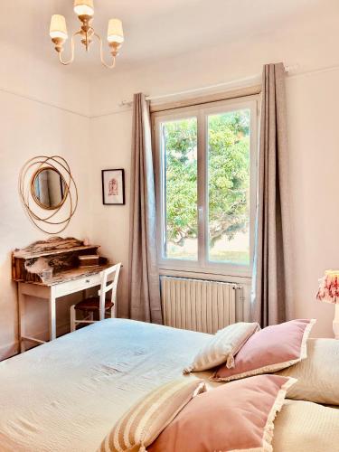 a bedroom with a bed and a desk and a window at Maison CÔTE OUEST in Labenne