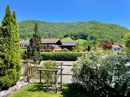 a view of a garden with a house in the background at Haus Zellerwirt in Ruhpolding