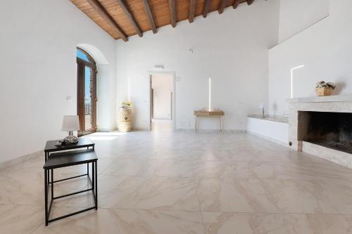 a large white room with a fireplace and a table at Sikania Agrirelais in Caccamo